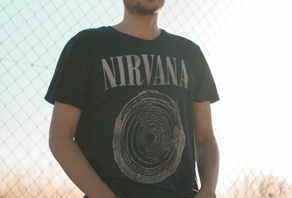 バンドグッズのロックTシャツを着ている人の画像